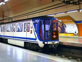 Metro de Madrid. Estação Marqués de Vadillo. Trem azul e branco visto na plataforma de embarque da estação visto lateralmente.